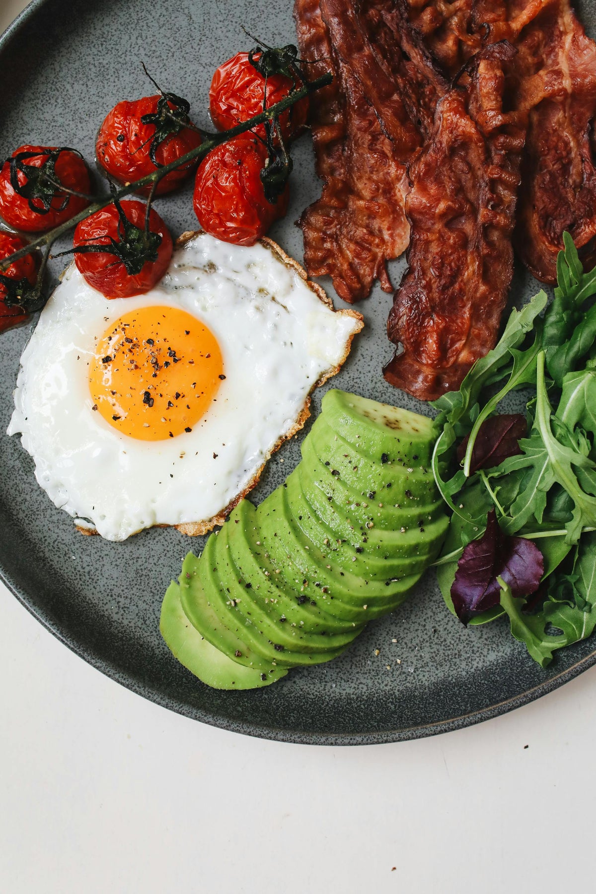 Huevos con tocino, aguacate y jitomates cherry con sal de tocino Toque de Aaron