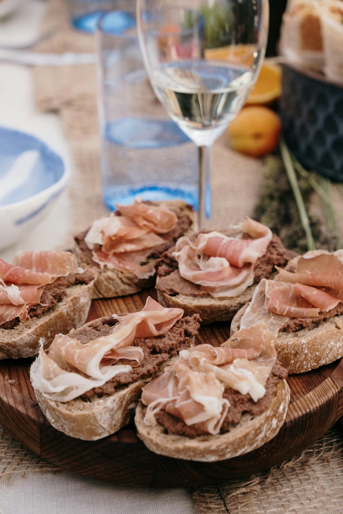 Tapas de pan con olivada de aceitunas Toque de Aaron y jamón serrano
